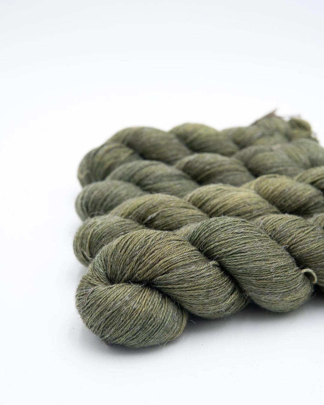 Matcha green colorway of organic wool linen and fingering yarn. It's a warm green.
